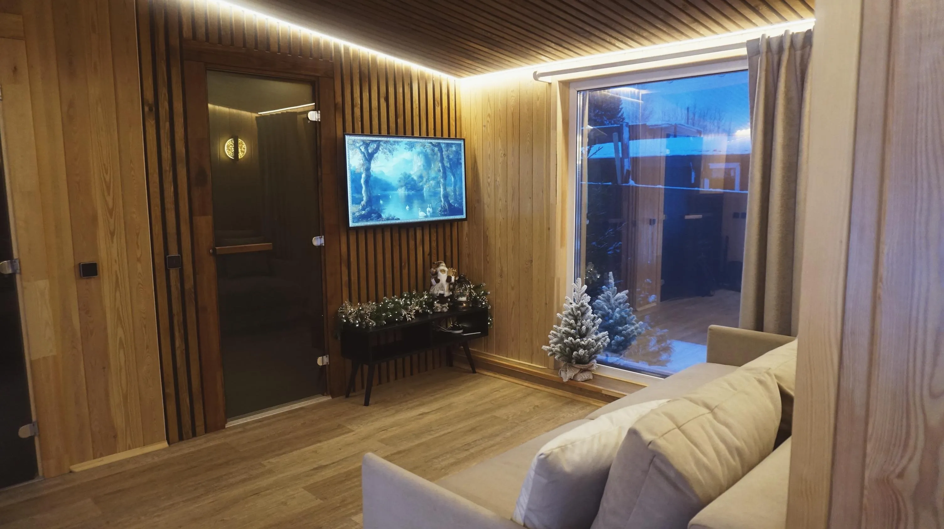 Зал дома-бани с диваном и телевизором