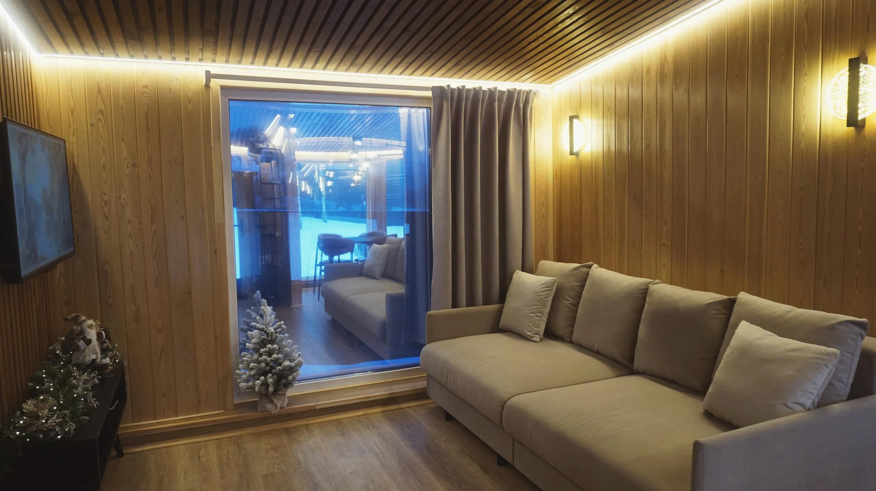 Панорамное окно и диван в гостиной дома-бани